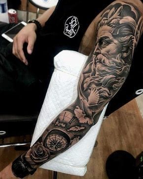 Masterful black and gray realism transforms this full sleeve into a dramatic narrative of Greek mythology and timeless beauty. The flowing composition seamlessly weaves together classical portraiture with intricate florals and geometric elements, creating depth that draws the eye from shoulder to wrist. A stunning example of how skilled shading and precise linework can turn skin into a living canvas of ancient artistry. ⚡