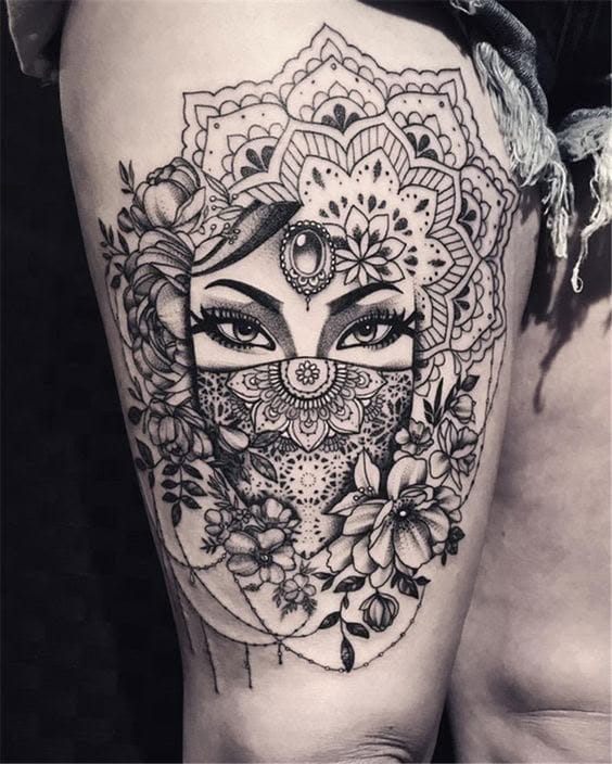 Intricate mandala patterns frame piercing feminine eyes in this breathtaking thigh piece that seamlessly blends spiritual symbolism with portrait artistry. The delicate lacework of geometric designs flows into blooming florals, creating a mesmerizing composition where sacred geometry meets natural beauty ✨ Every line tells a story of divine femininity and inner wisdom.