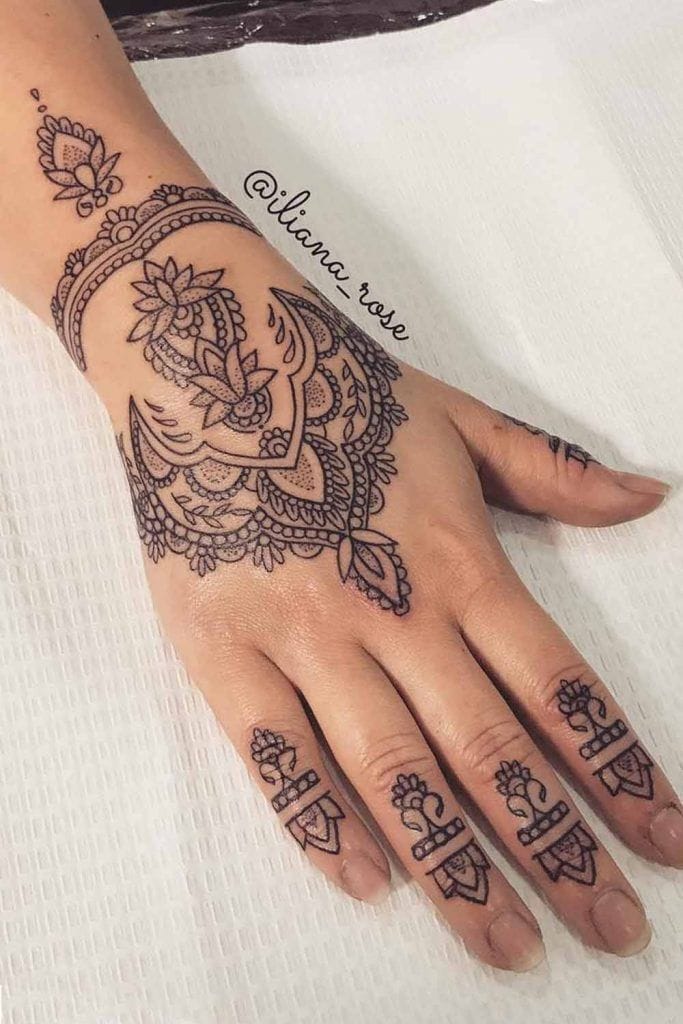 Delicate mandala petals cascade across the hand like an intricate lace glove, with matching finger details that create a cohesive bridal-worthy design. The flowing botanical elements wrap gracefully from wrist to fingertips, transforming the entire hand into a canvas of ornate symmetry that's both bold and elegantly feminine ✨