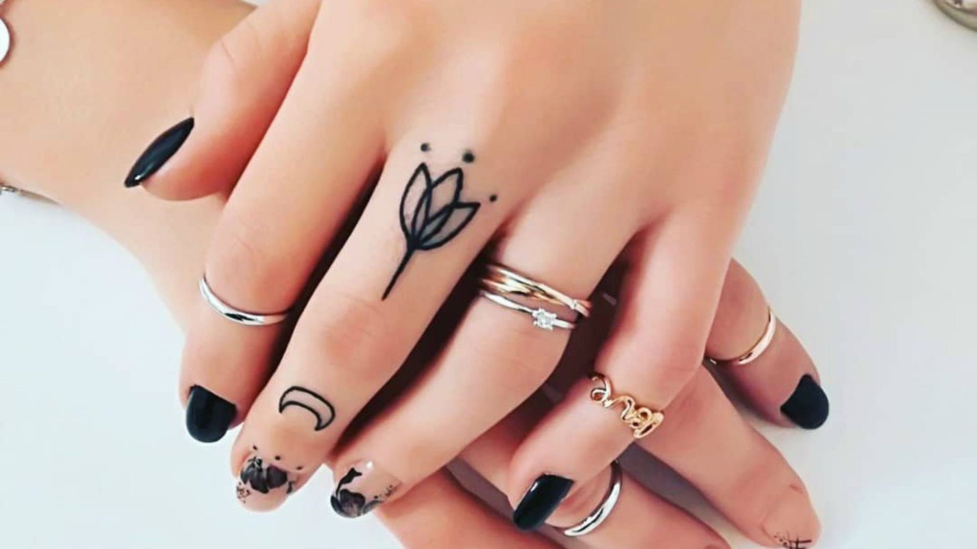 Delicate black ink blooms across knuckles in this stunning finger tattoo collection, featuring a minimalist tulip design that transforms everyday hand gestures into artful expressions. The fine linework and strategic placement create an effortlessly chic aesthetic that's both understated and striking 🌷