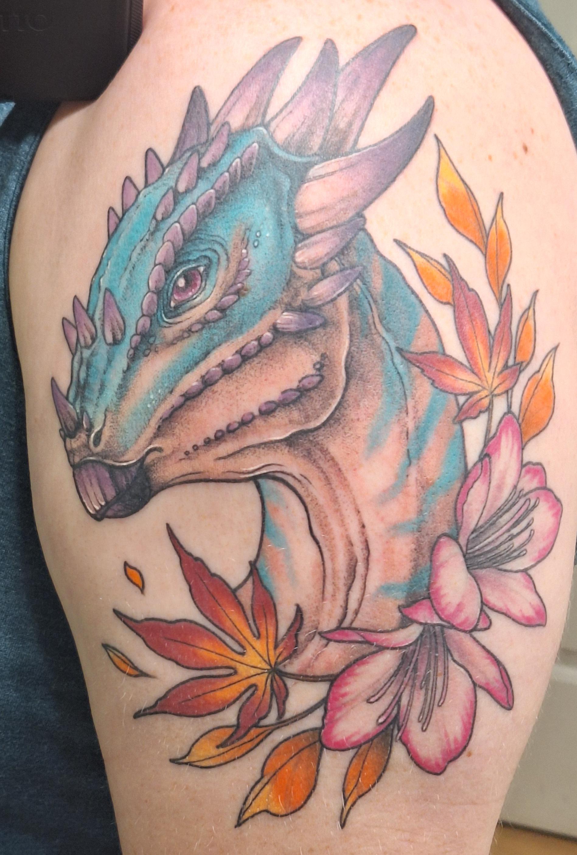 Mesmerizing neo-traditional artistry brings this turquoise dragon to life alongside delicate autumn florals 🍂 The artist's masterful shading creates incredible depth in the creature's scaled features, while vibrant maple leaves and pink blossoms add an unexpected softness to balance the dragon's fierce presence. Perfect thigh placement allows this fantasy masterpiece to flow naturally with the body's curves.