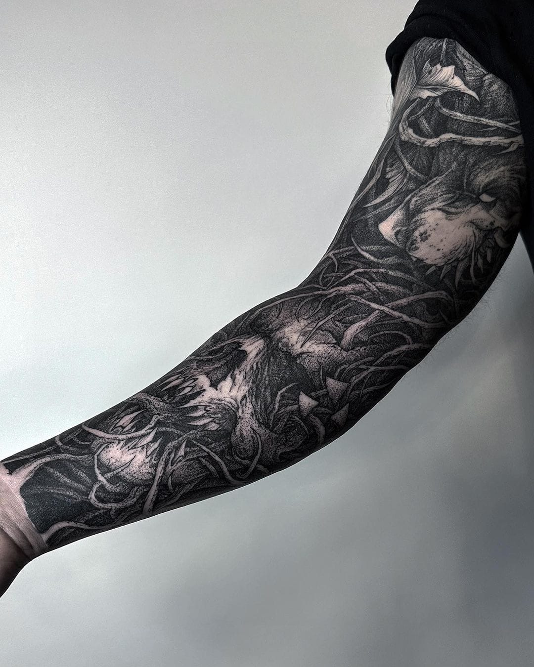 Dark botanical artistry flows seamlessly across this full sleeve, where intricate leaves and organic forms create a mesmerizing tapestry in rich black ink. The masterful shading technique gives incredible depth to each element, making the flora appear to dance and intertwine as it wraps around the arm 🖤 This blackwork masterpiece proves that nature-inspired tattoos can be both bold and beautifully sophisticated.