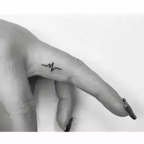 A delicate heartbeat line pulses across the side of this finger, transforming medical imagery into deeply personal body art. The minimalist black ink creates an intimate reminder that life's rhythm is always with you, perfectly positioned where only you and those closest to you will notice. Simple yet profound, this tiny tattoo proves that the most meaningful designs don't need to shout to make an impact ⚡
