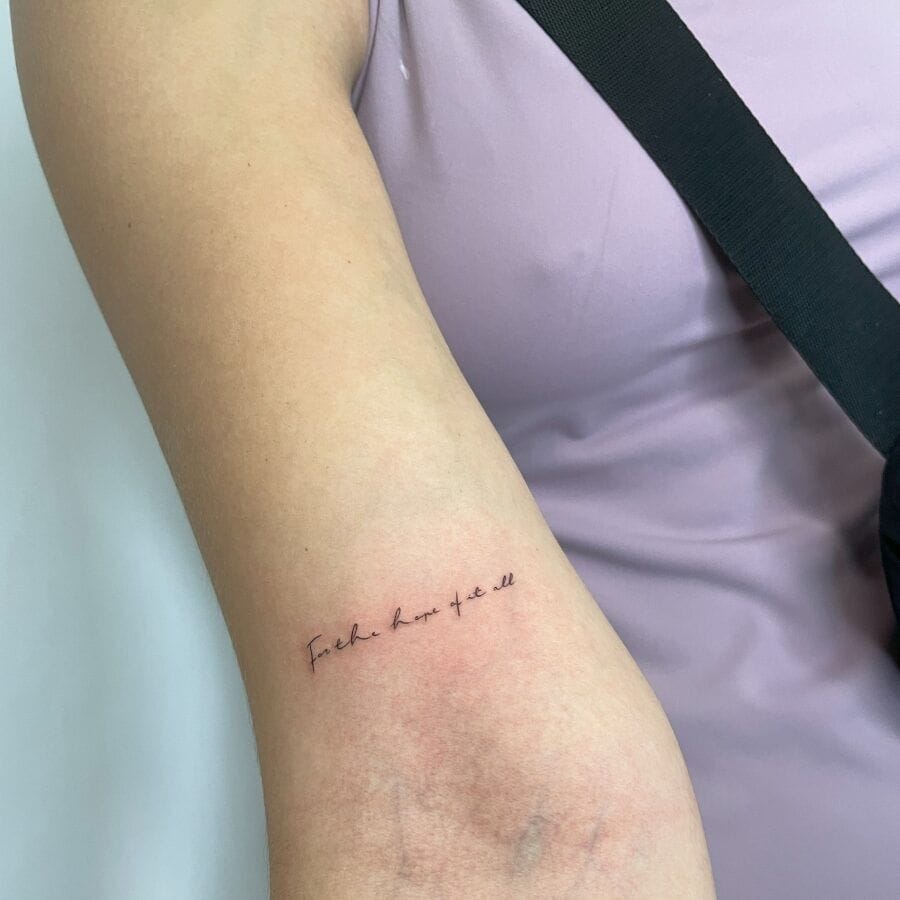 Delicate script flows across the forearm like a whispered mantra, with 