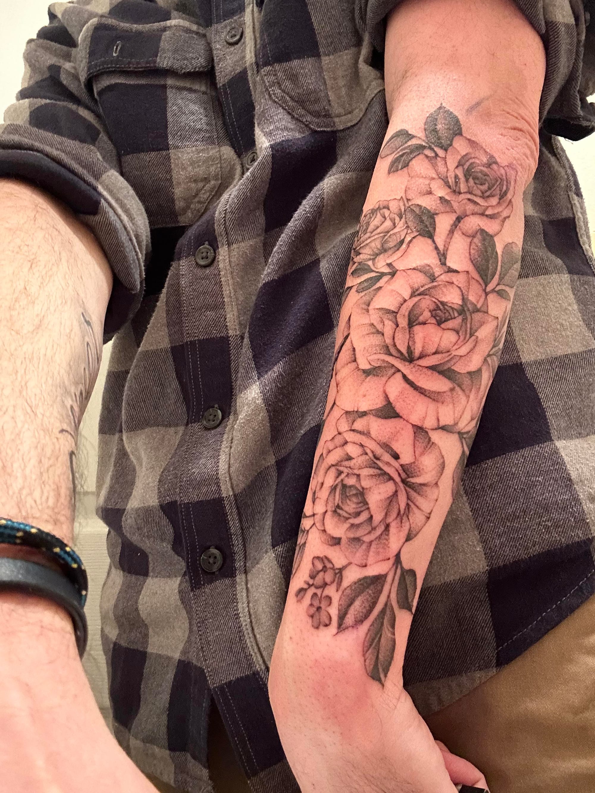 Cascading down the forearm like a botanical masterpiece, this black and grey rose sleeve showcases exquisite shading and dimensional depth that makes each bloom appear to lift off the skin. The artist's masterful use of dotwork and fine line techniques creates stunning texture in every petal, while the organic flow perfectly complements the arm's natural contours 🌹