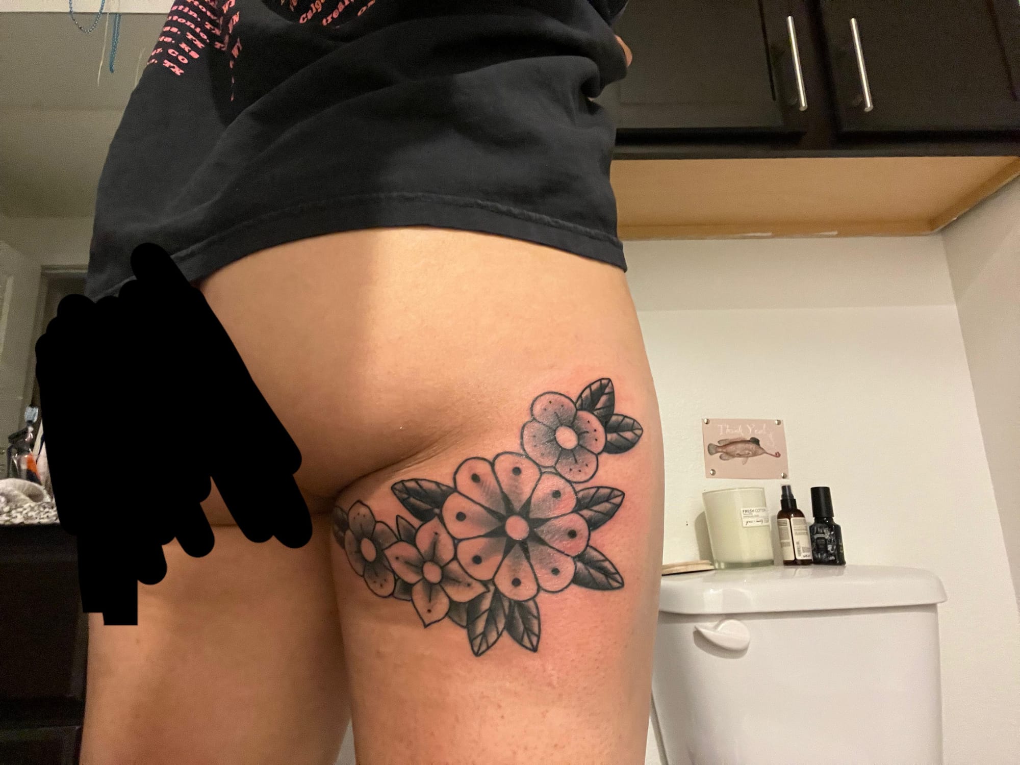 Delicate dotwork flowers bloom across this thigh placement, showcasing the perfect balance between feminine florals and bold traditional styling. The clustered arrangement and subtle shading create beautiful depth while the dotted petals add a unique textural element that sets this piece apart from typical flower tattoos. 🌸