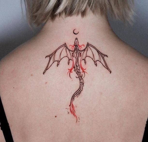 Delicate linework meets fiery accents in this stunning dragon spine tattoo that perfectly follows the natural curve of the back. The minimalist black outline contrasts beautifully with strategic pops of red ink, while the crescent moon adds an mystical celestial element above the outstretched wings 🌙 Pure artistry that transforms the spine into a mythical canvas.