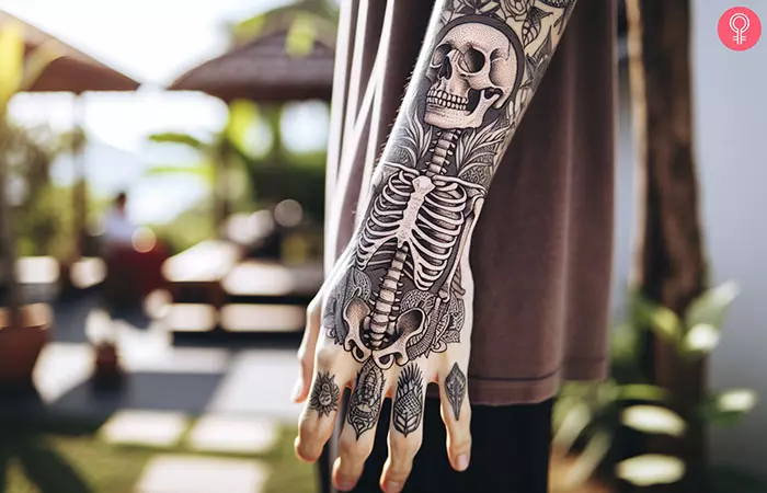 Dark artistry flows down this arm like a gothic tapestry, where intricate skeleton imagery dances with ornate floral elements in stunning black and gray realism. The seamless transition from forearm to hand creates a cohesive masterpiece that transforms the entire limb into a canvas of mortality and beauty. ⚰️