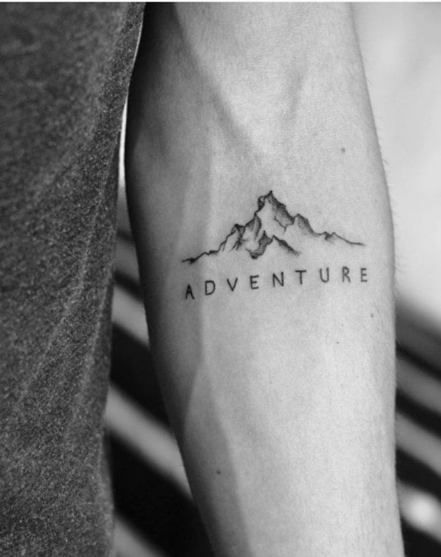 Delicate line work transforms this forearm into a canvas for wanderlust, where jagged mountain peaks rise beneath the simple yet powerful word 