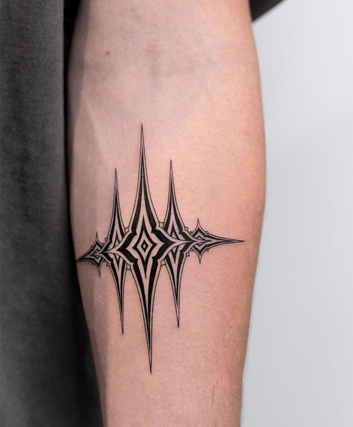 Sharp geometric spikes burst outward from a central diamond core, creating an almost crystalline explosion of ink on this forearm canvas. The precise linework and symmetrical design gives off major tribal-meets-modern vibes, like wearing a piece of architectural art that's both elegant and edgy ⚡