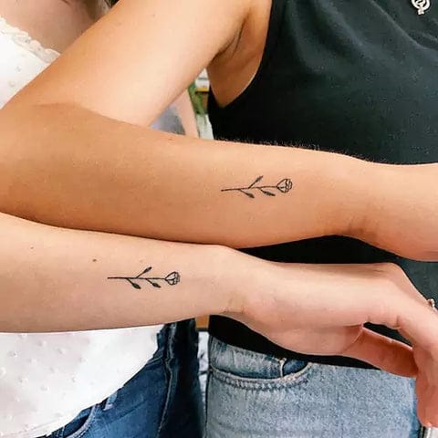 Simple stems crowned with delicate blooms create an understated yet meaningful connection between these two souls. The matching placement on both forearms transforms a minimalist botanical design into a powerful symbol of shared growth and blooming together 🌸 Perfect for couples who believe in subtle statements that speak volumes.
