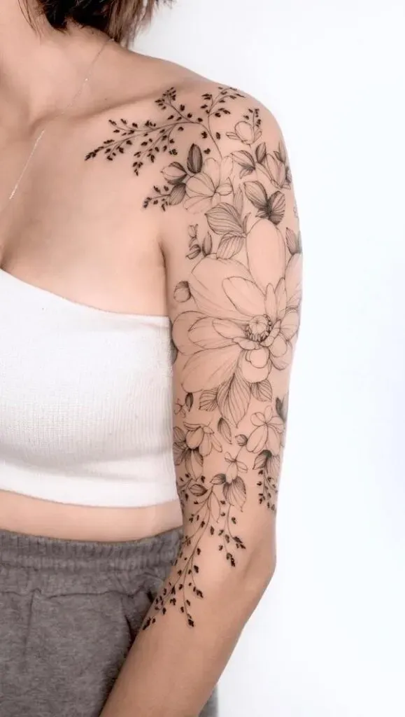 Delicate botanical artistry cascades down this entire arm like a garden in bloom, featuring intricate line work that flows from shoulder to wrist in perfect harmony. The mix of bold florals and wispy trailing elements creates such beautiful movement and depth - it's like wearing nature's poetry on your skin 🌸