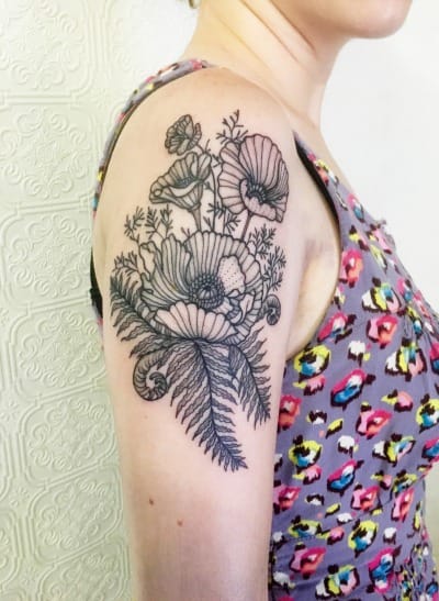 Delicate linework transforms this shoulder into a botanical wonderland, where intricate poppies and wildflowers dance across the skin in stunning black ink detail. The artistic placement creates a natural flow from shoulder to upper arm, making this floral piece feel like it's growing organically from within 🌸