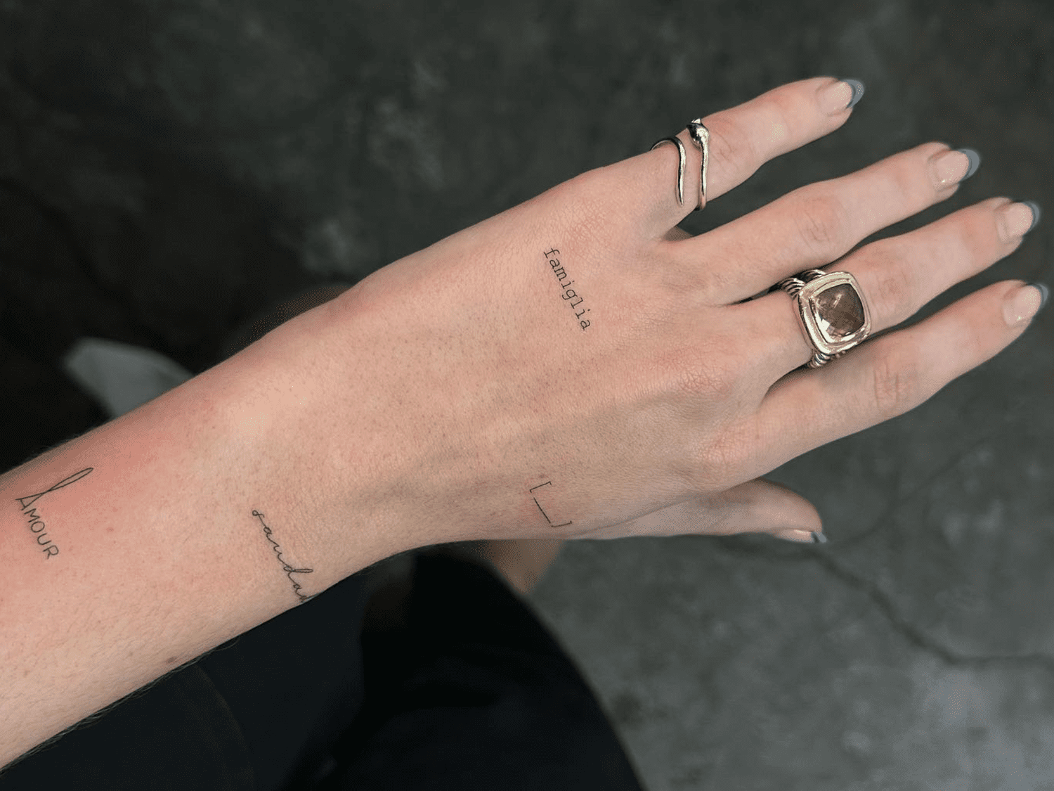 Delicate minimalist script transforms this hand into a personal manifesto, with thoughtfully placed words creating an intimate roadmap of values and identity. The subtle lettering flows naturally across fingers and palm, turning everyday gestures into quiet declarations of self ✨