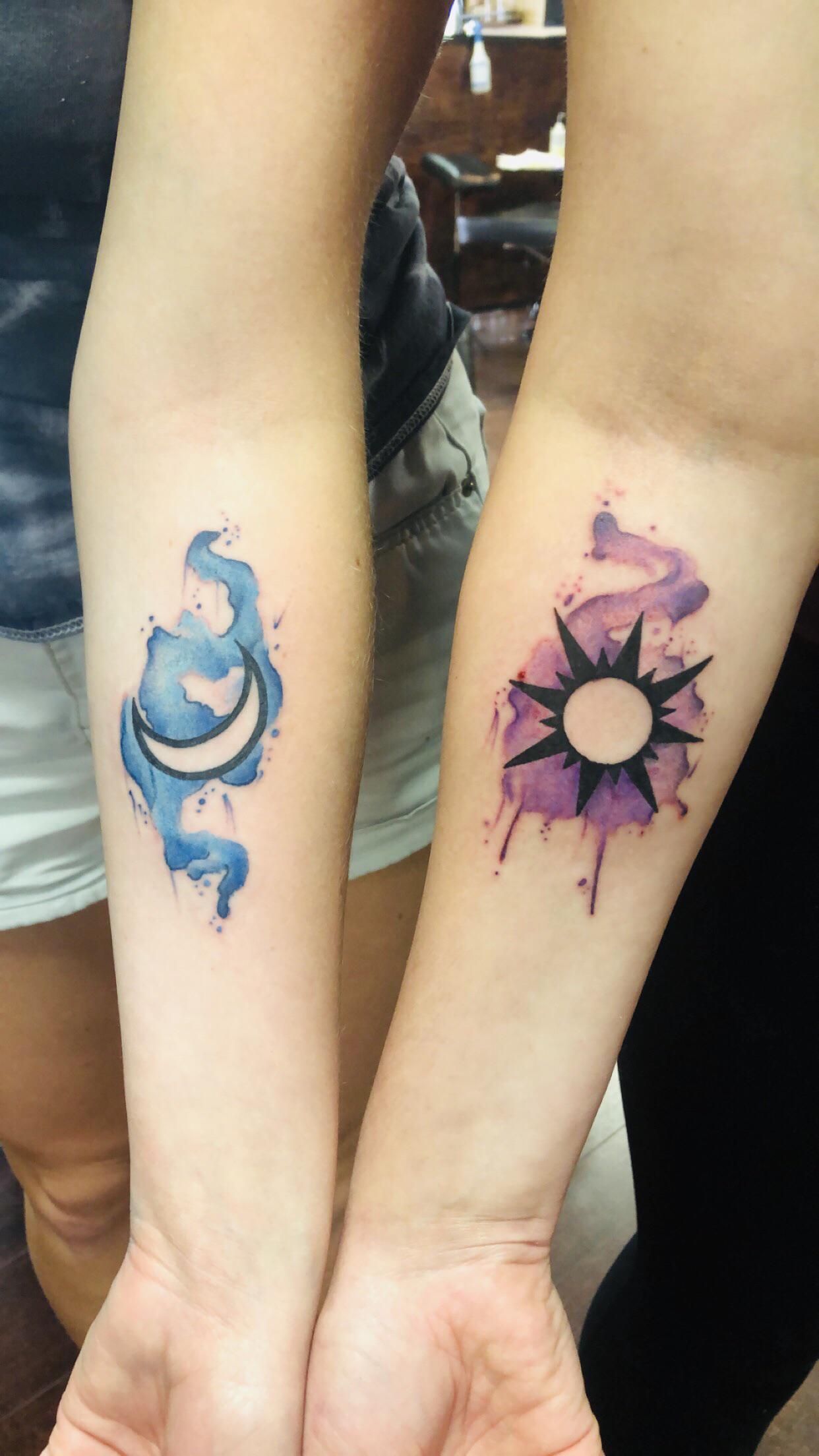 Watercolor magic meets celestial symbolism in these stunning forearm pieces - a dreamy blue crescent moon flows alongside a radiant purple sun, creating the perfect yin-yang balance. The artistic splashes and drips give both tattoos an ethereal, painterly quality that transforms skin into canvas. Perfect matching ink for couples who represent each other's light and shadow! 🌙☀️