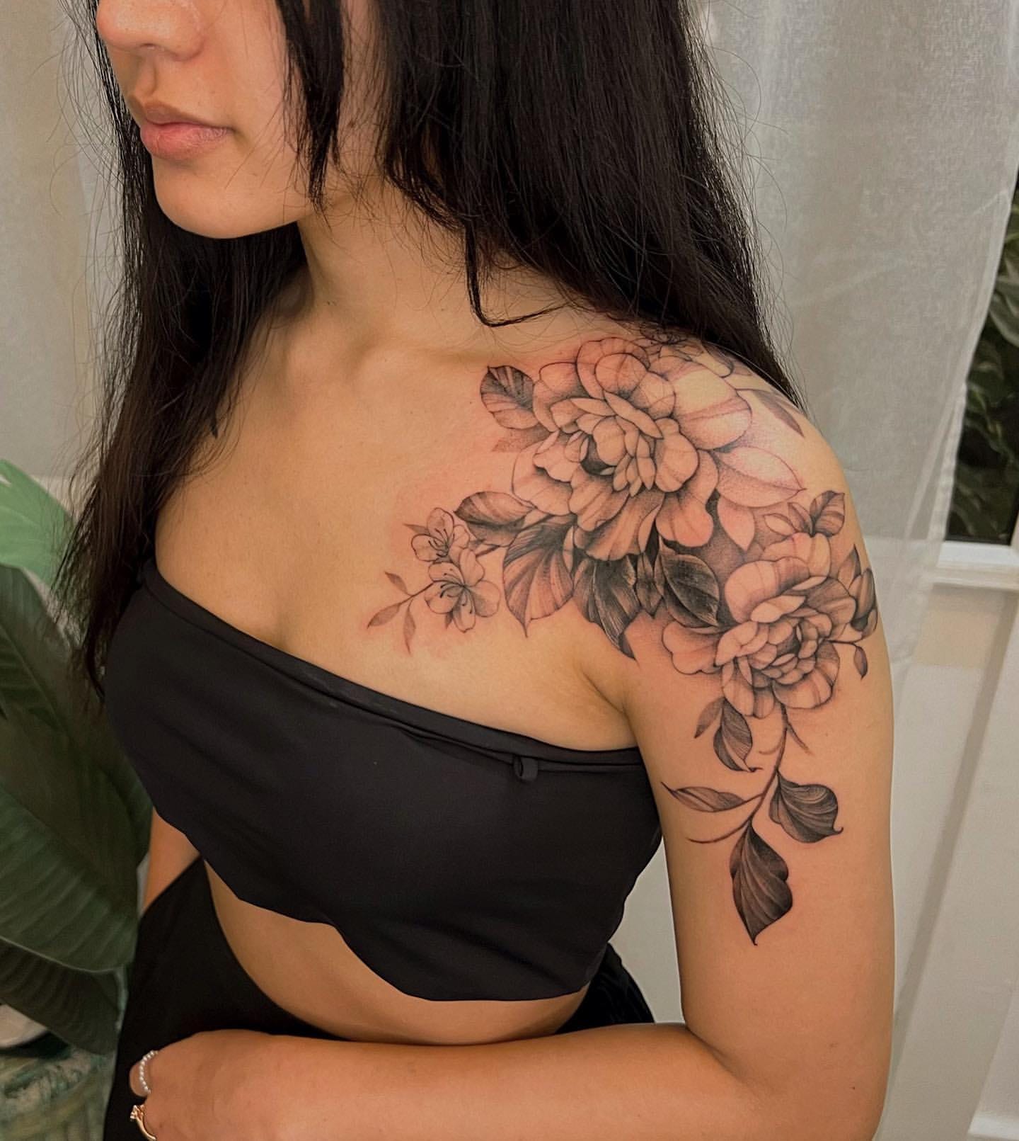 Cascading down from shoulder to arm, this botanical masterpiece transforms skin into a canvas of blooming artistry. The delicate linework and soft shading create dimensionality that makes each petal seem ready to flutter in a gentle breeze, while the flowing composition follows the natural curves of the body with effortless grace. 🌸