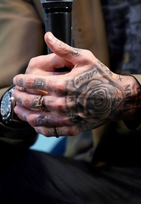 Intricate blackwork cascades across both hands in this stunning display of commitment to the craft 🖤 A bold rose blooms prominently among script lettering and geometric elements, creating a cohesive sleeve that flows seamlessly from knuckles to wrists. The dense coverage and masterful line work showcase how hand tattoos can become wearable art when executed with this level of precision.