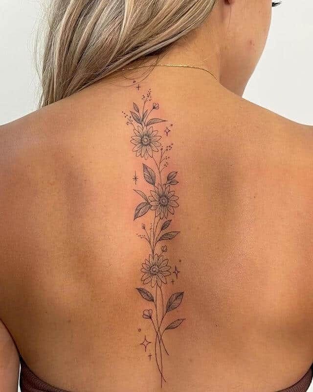Delicate sunflowers cascade down the spine in this breathtaking fine line masterpiece, each bloom connected by graceful stems and scattered with tiny celestial stars ✨ The intricate shading and botanical details create a stunning vertical garden that perfectly follows the natural curve of the back, making this piece both elegant and deeply symbolic of growth and resilience.
