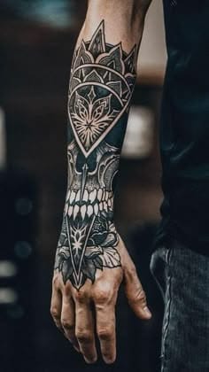 Geometric precision meets gothic darkness in this stunning forearm piece where crystalline diamond patterns flow seamlessly into an intricate skull design. The artist's masterful use of negative space and fine linework creates incredible depth, while the strategic placement wrapping around the wrist adds dynamic movement to every gesture ⚡ Bold blackwork at its absolute finest.