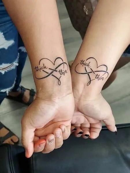 When two souls unite, their bond becomes eternal - beautifully captured in these matching infinity symbol wrist tattoos that spell out 