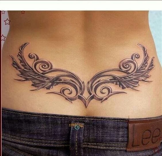 Graceful wings unfurl across the lower back in this stunning piece, where delicate feathers blend seamlessly with ornate scrollwork to create movement that seems to lift right off the skin. The symmetrical design frames the natural curves beautifully, while the intricate linework showcases the artist's masterful attention to detail ✨