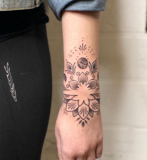 Delicate dotwork cascades down this forearm like celestial rain, creating a mesmerizing mandala that flows from wrist to elbow with botanical grace. The intricate linework weaves together floral motifs and geometric patterns, while subtle shading adds depth to what appears to be a moon or cosmic element at the center. Pure artistry that transforms the arm into a living canvas of nature-inspired mysticism ✨