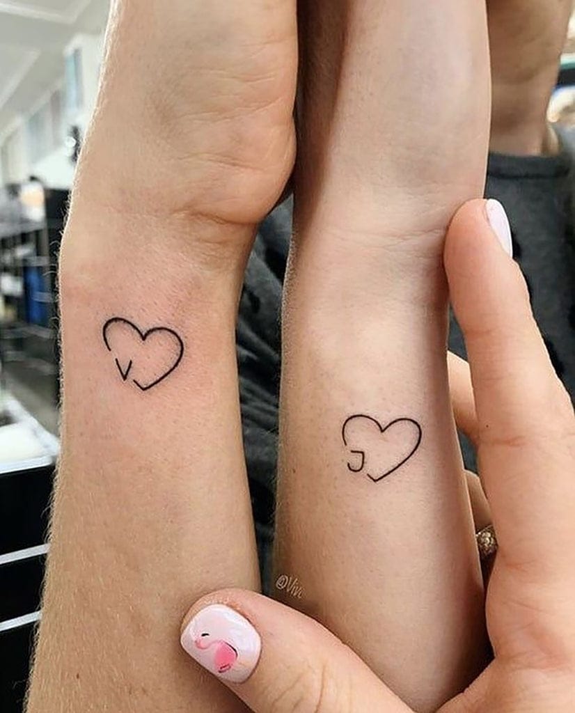 Complementary hearts create the perfect puzzle piece connection on these matching wrists - one features a delicate outline while the other showcases a subtle cut-out design that would align when hands touch. The minimalist linework and strategic placement make this couple's tattoo both intimate and effortlessly chic ✨ Simple yet symbolic, these hearts prove that the most meaningful tattoos don't need to be elaborate.