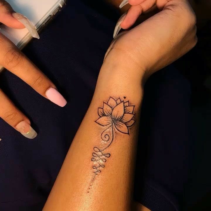 Graceful dotwork petals unfurl into a stunning lotus bloom, while delicate script cascades down the forearm like morning dewdrops ✨ The intricate line art creates beautiful contrast against warm skin, transforming this arm into a canvas of feminine elegance and spiritual symbolism.
