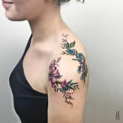 Cascading down the shoulder like nature's own masterpiece, this delicate floral composition weaves together dusty roses and verdant foliage in perfect harmony. The artist's skilled hand has created an organic flow that follows the natural curves of the arm, making each bloom appear to grow effortlessly from the skin itself. 🌿