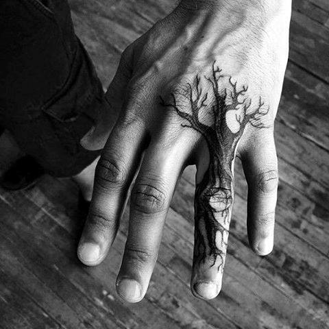 Nature's delicate beauty takes root across knuckles and fingers in this stunning black ink masterpiece. The bare-branched tree stretches organically from thumb to pinky, creating an enchanting forest scene that moves with every gesture—turning simple hand movements into living art that celebrates the raw elegance of winter landscapes. 🌿