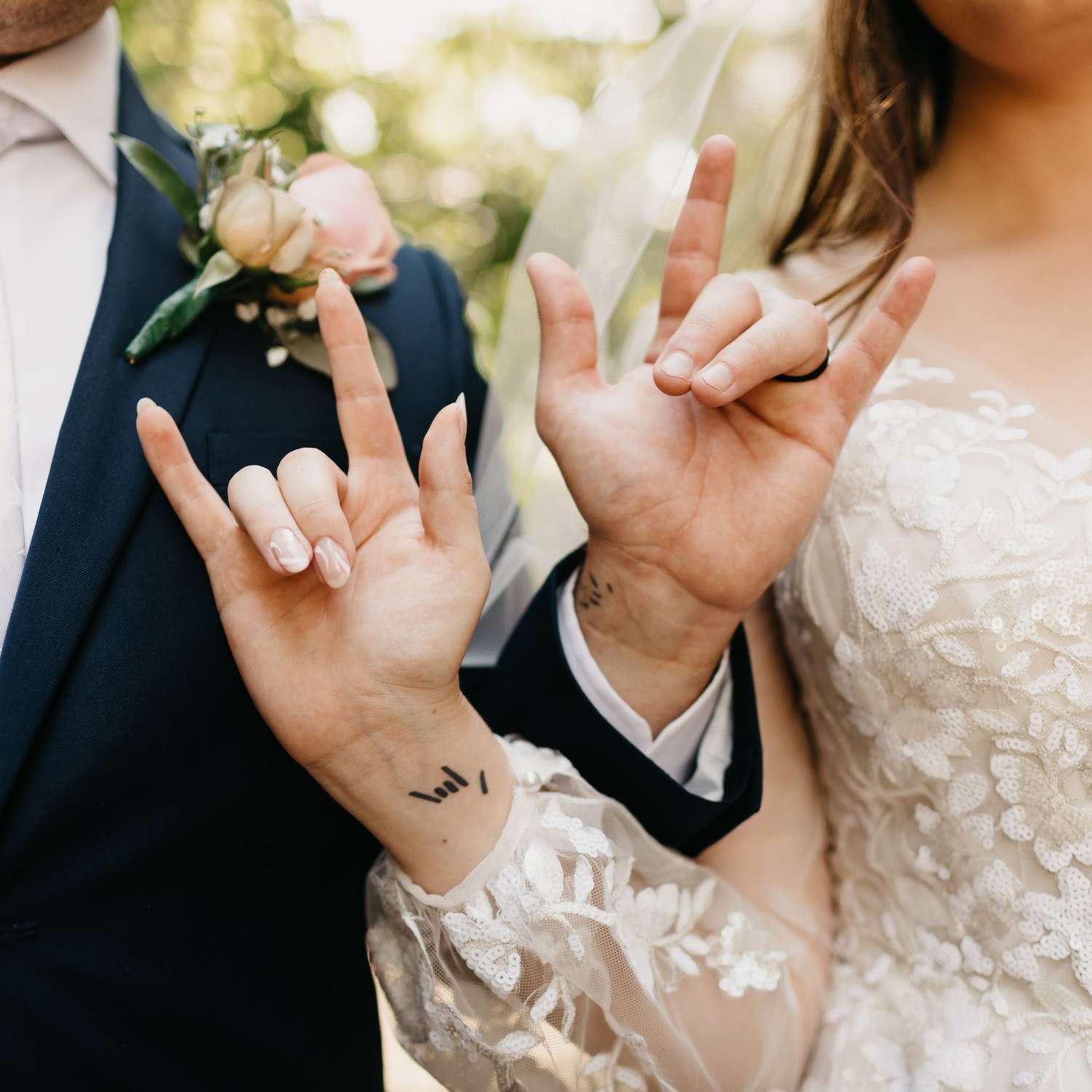 Delicate script dances across the bride's wrist, creating an intimate moment of connection as she and her partner flash matching 