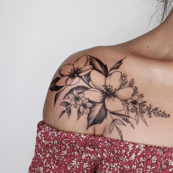 Delicate hibiscus blooms cascade across the shoulder blade in this stunning black and gray botanical piece, creating a natural flow that follows the body's curves perfectly. The fine line work and subtle shading give each petal incredible depth, while trailing lavender sprigs add an extra touch of feminine elegance 🌺