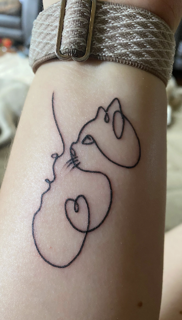 Delicate line work brings this minimalist mouse to life on the forearm, capturing pure whimsy in simple black ink. The sweet creature appears to be mid-dance or gentle movement, with flowing curves that follow the natural contours of the arm perfectly 🐭