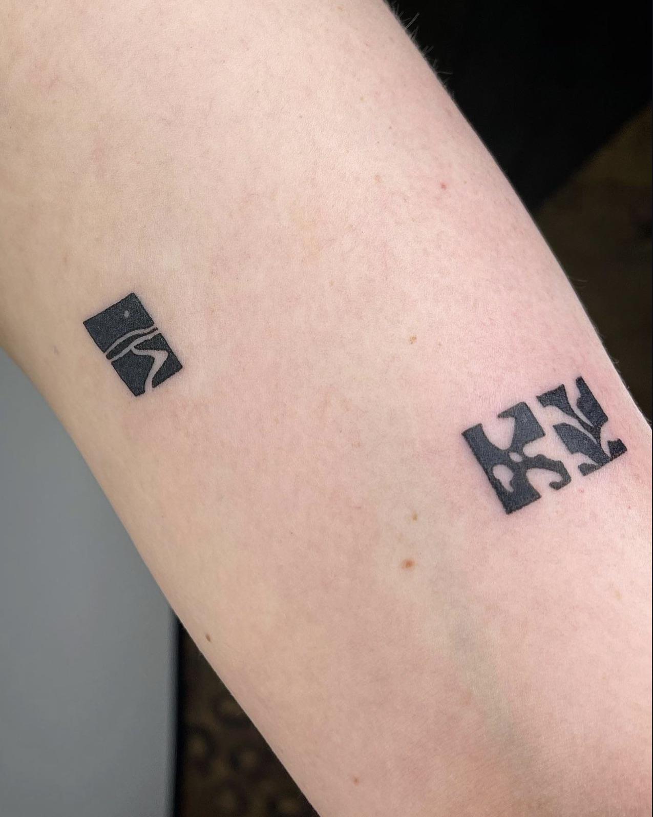 Minimalist perfection meets tech-savvy style with these crisp black logos adorning the forearm like digital badges of honor. The clean linework and strategic spacing create a modern aesthetic that speaks to brand loyalty and personal identity, while the geometric precision gives off serious graphic designer vibes ⚡