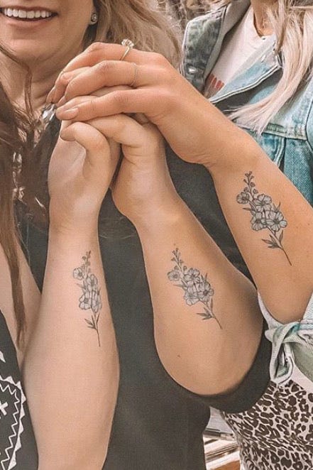 Delicate wildflower stems bloom across both forearms in this beautifully symmetrical design, creating an enchanting botanical garden that moves with every gesture. The fine line work and subtle shading give these matching florals an almost watercolor-like quality, while their placement transforms the arms into living canvases 🌿 Perfect for those who want nature-inspired ink that feels both feminine and timeless.