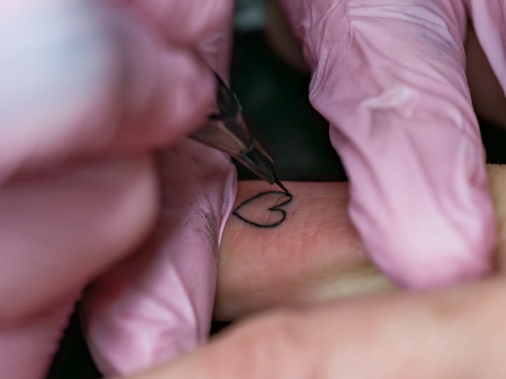 A woman getting a tattoo on her arm
